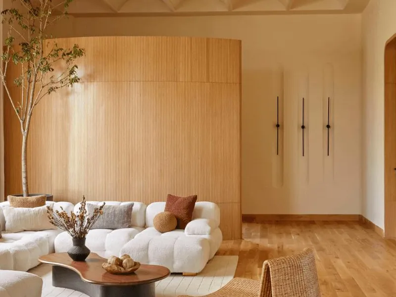 Curved fluted wood wall panelling behind a white sofa