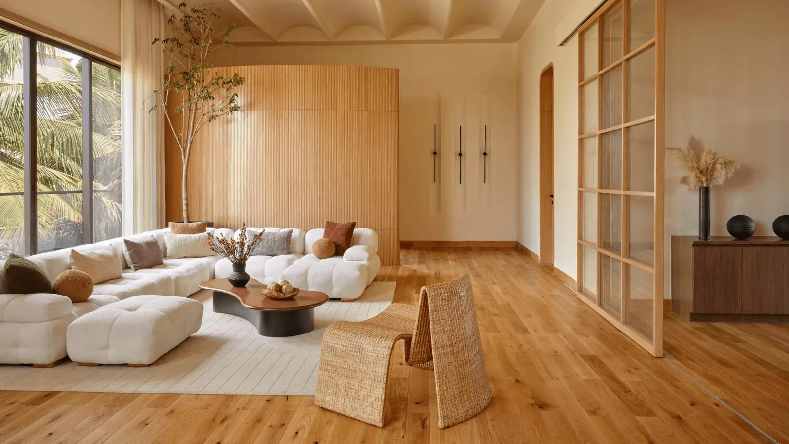 Living room with warm oak wooden flooring and a curved fluted wall panel